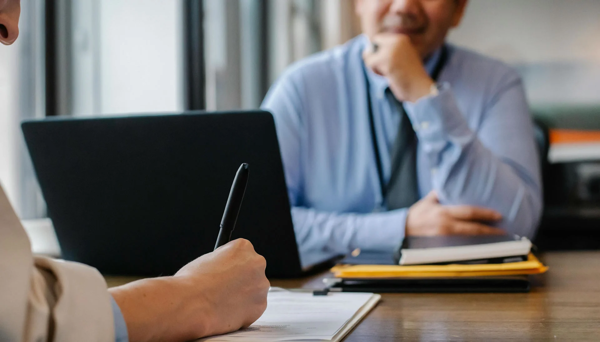 Woman filling job application form in office with boss